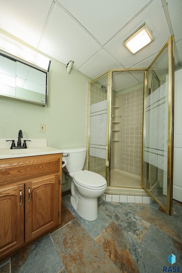 full bath with a stall shower, toilet, and vanity