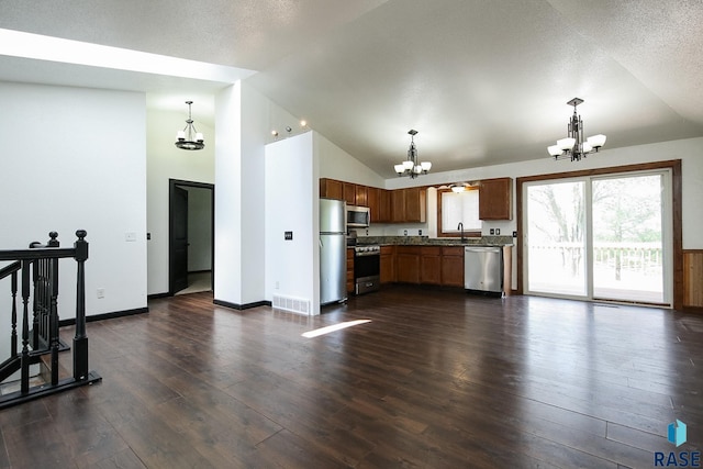 kitchen with a chandelier, stainless steel appliances, decorative light fixtures, a sink, and dark wood finished floors
