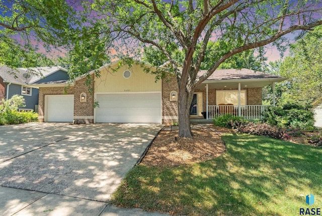 single story home with brick siding, a garage, driveway, a porch, and a front lawn