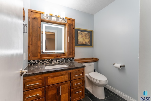 half bath with tile patterned flooring, toilet, decorative backsplash, vanity, and baseboards