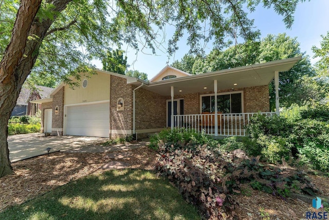 single story home featuring brick siding, a porch, an attached garage, and driveway
