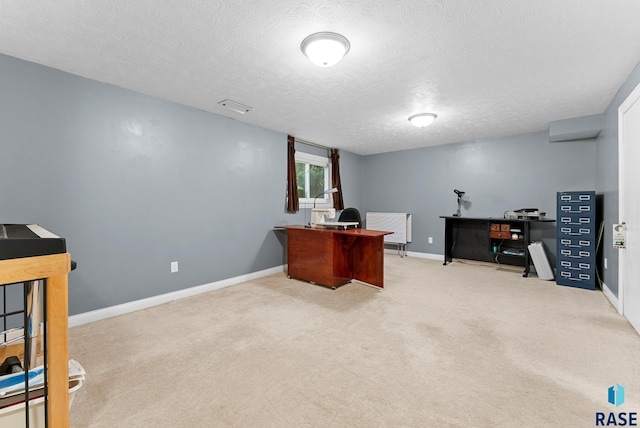 carpeted home office with a textured ceiling and baseboards