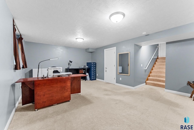 office area featuring a textured ceiling, carpet floors, and baseboards
