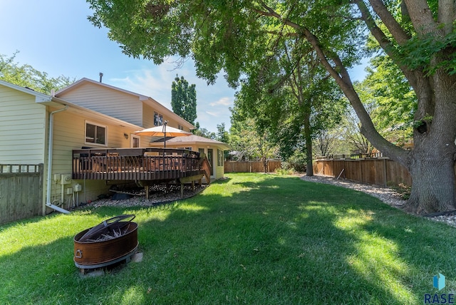 view of yard featuring a deck and an outdoor fire pit