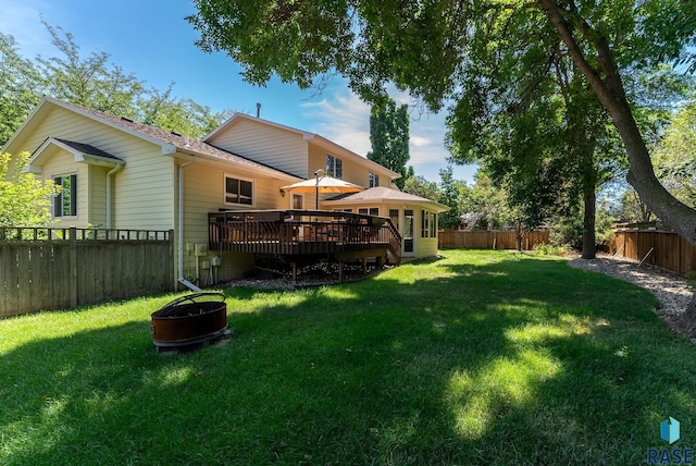 view of yard featuring a wooden deck and an outdoor fire pit