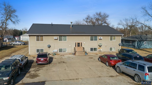 301 W Prospect Ave, Flandreau, SD 57028 - back of house with metal roof, uncovered parking, and entry steps