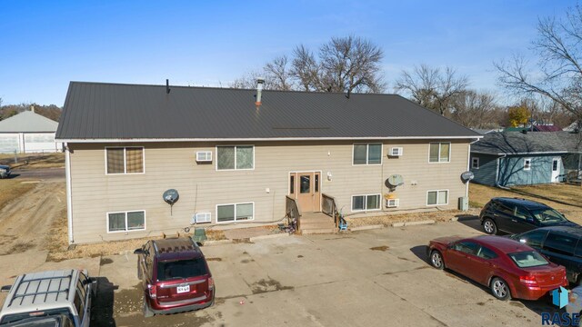 301 W Prospect Ave, Flandreau, SD 57028 - rear view of property with metal roof, uncovered parking, and a wall mounted AC