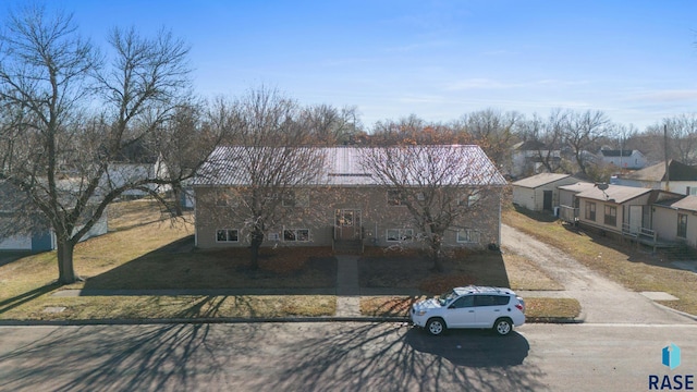 301 W Prospect Ave, Flandreau, SD 57028 - townhome / multi-family property with dirt driveway, a front yard, a residential view, and metal roof