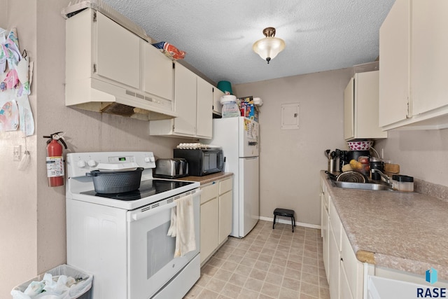 301 W Prospect Ave, Flandreau, SD 57028 - kitchen featuring white appliances, under cabinet range hood, a sink, light countertops, and a textured ceiling