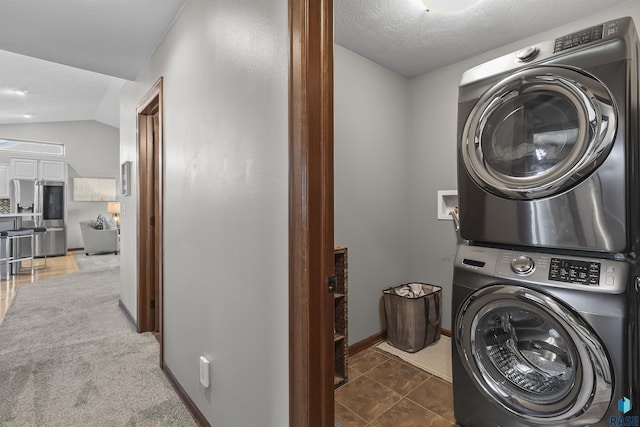 washroom with stacked washing machine and dryer and baseboards