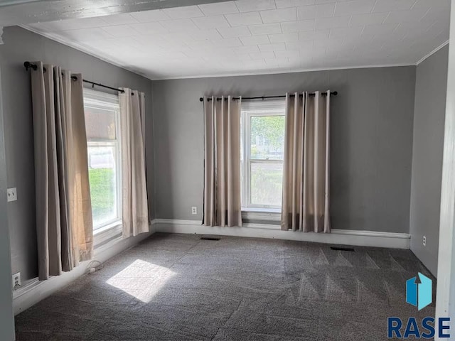 unfurnished room with crown molding, carpet flooring, and baseboards