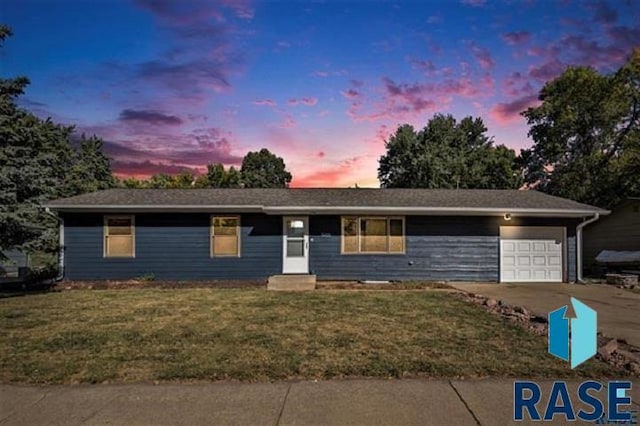 single story home featuring a garage, concrete driveway, a lawn, and entry steps