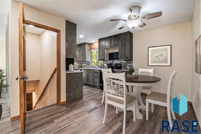 kitchen with black microwave, wood finished floors, light countertops, and ceiling fan