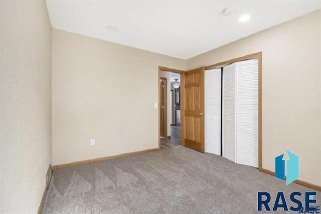 unfurnished bedroom with carpet, baseboards, and a closet