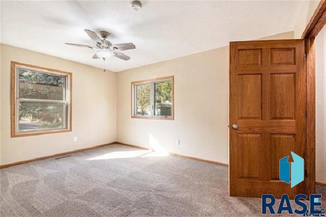 unfurnished room with carpet floors, baseboards, a ceiling fan, and a smoke detector