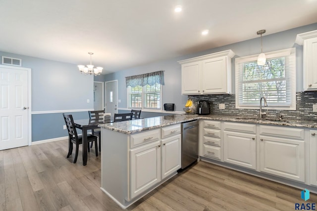 kitchen featuring a sink, dishwasher, white cabinets, a peninsula, and recessed lighting