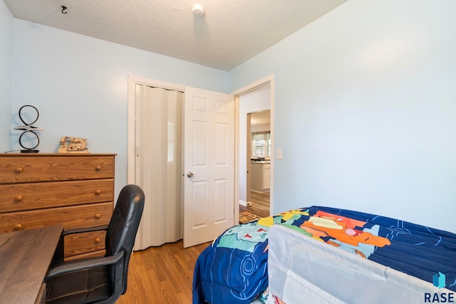 bedroom featuring light wood-style floors and a desk