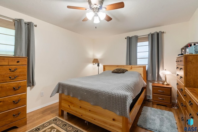 bedroom with baseboards, light wood-style floors, and a ceiling fan