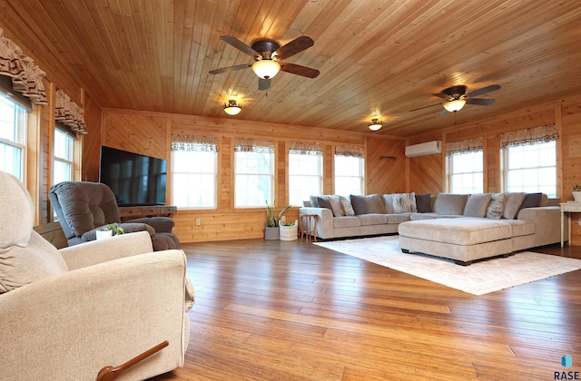 47743 233a St, Egan, SD 57024 - living room featuring a ceiling fan, a wall mounted air conditioner, wood walls, healthy amount of natural light, and wood ceiling