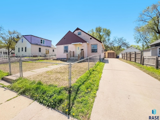 bungalow-style house with concrete driveway and an outdoor structure