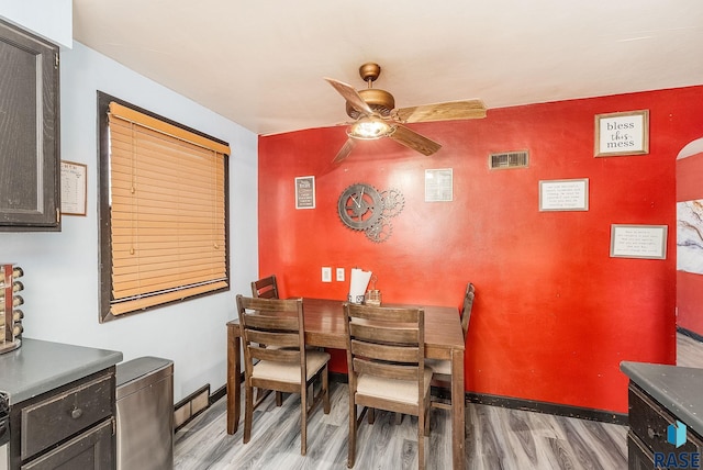 dining area featuring light wood-style floors, ceiling fan, and baseboards