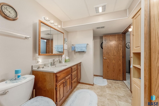 bathroom featuring vanity, toilet, and baseboards