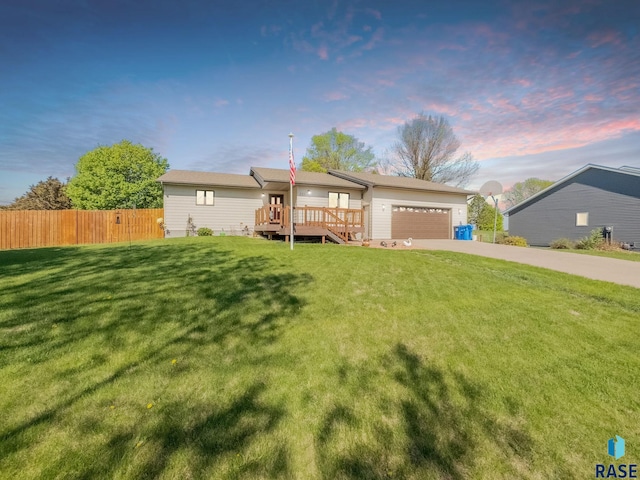 ranch-style home featuring driveway, a garage, and a wooden deck