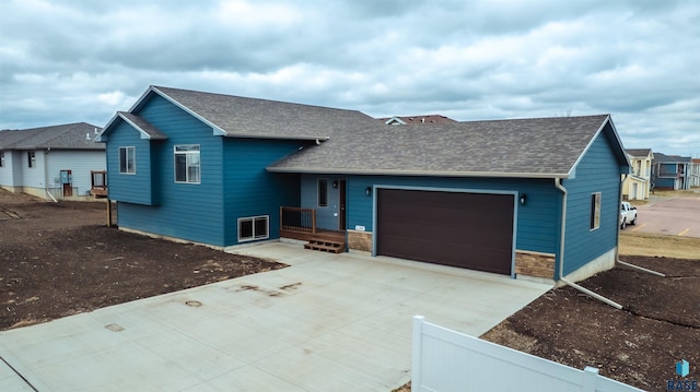 1180 Ruud Trl, Hartford, SD 57033 - view of front of property with roof with shingles, a garage, driveway, and fence