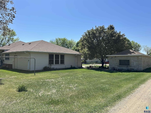 view of home's exterior featuring a lawn and roof with shingles
