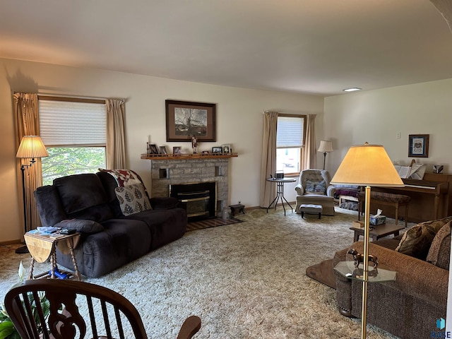 carpeted living area with a stone fireplace