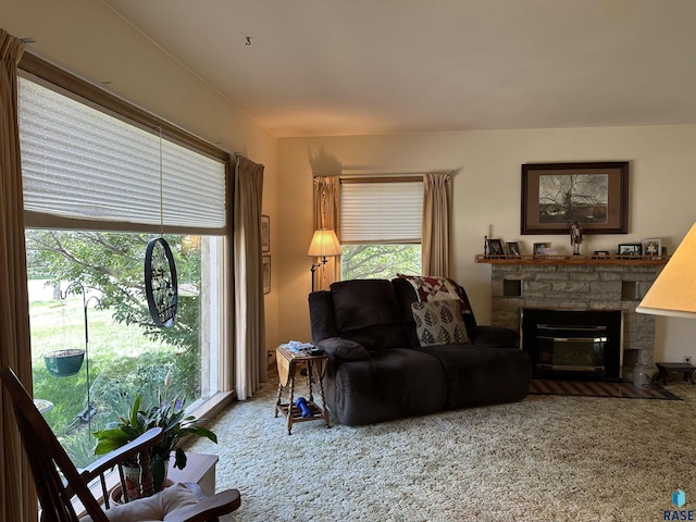 living room featuring carpet floors and a stone fireplace