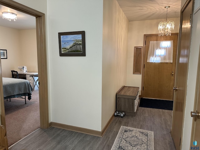 foyer featuring wood finished floors, a chandelier, and baseboards