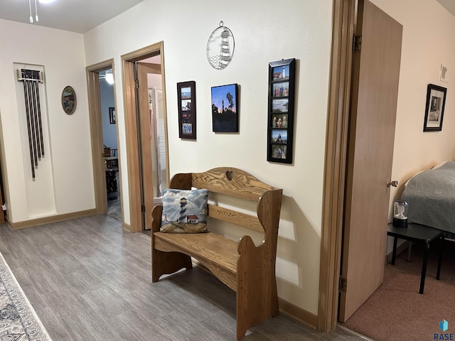 corridor featuring wood finished floors and baseboards
