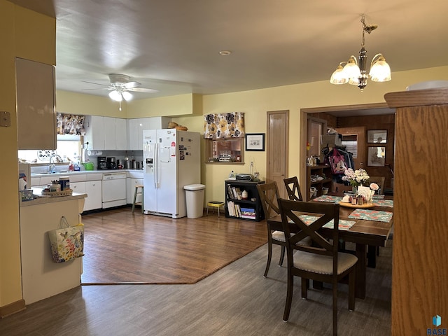 dining area with a chandelier, a ceiling fan, and dark wood-style floors