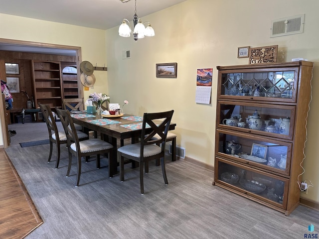 dining area with a chandelier, wood finished floors, and baseboards