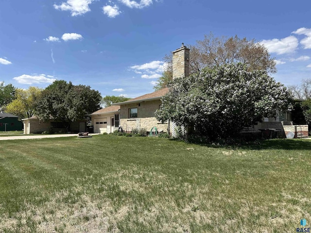 view of green lawn with an attached garage