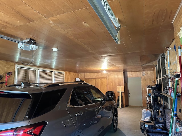 garage featuring wooden walls, a garage door opener, and wooden ceiling