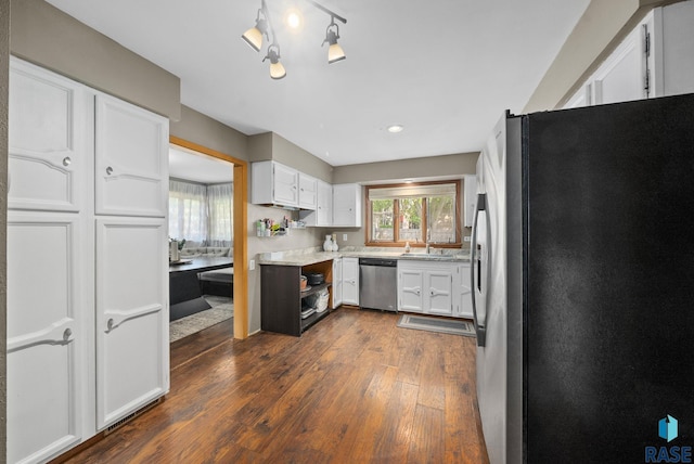 kitchen featuring appliances with stainless steel finishes, dark wood-style flooring, white cabinets, and a sink