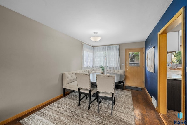 dining room featuring dark wood finished floors and baseboards