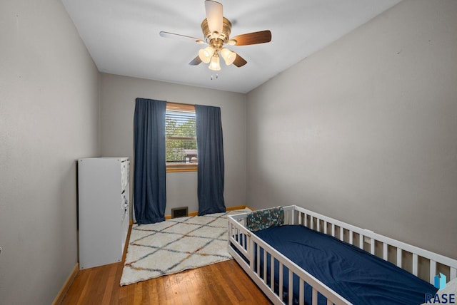 bedroom featuring wood finished floors, ceiling fan, and baseboards