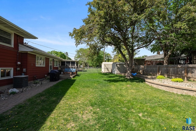 view of yard with central AC, a shed, and an outbuilding
