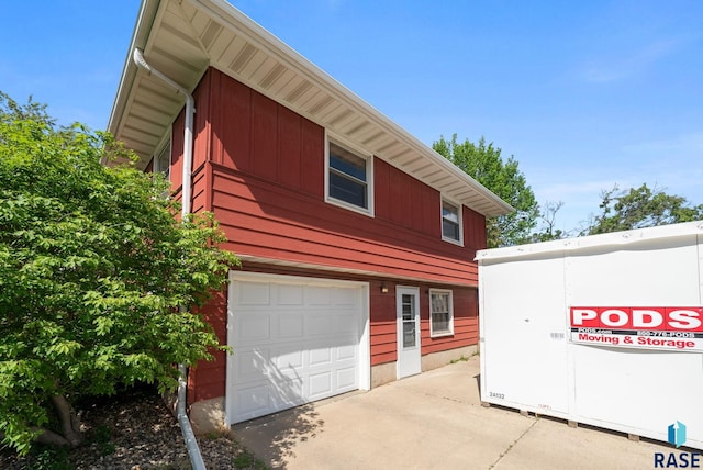 view of side of home with a garage and concrete driveway