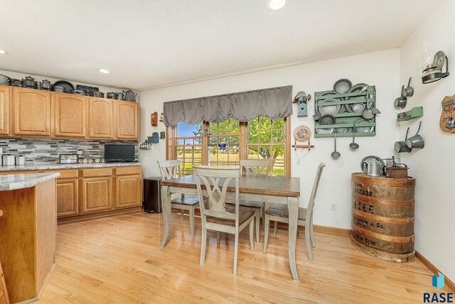 kitchen with light wood-type flooring, backsplash, recessed lighting, and baseboards