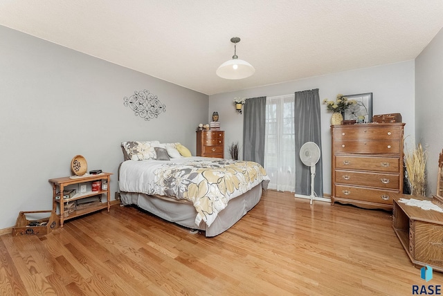 bedroom with light wood-style floors and baseboards