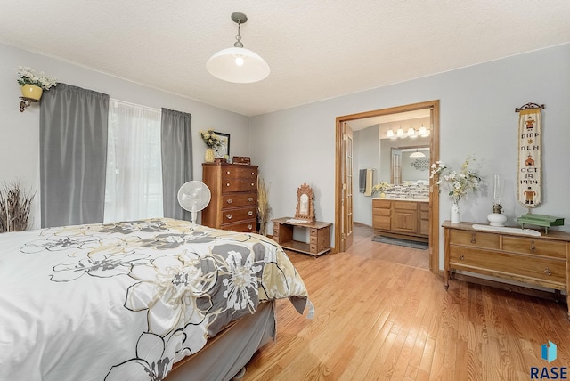 bedroom featuring light wood-type flooring and ensuite bathroom