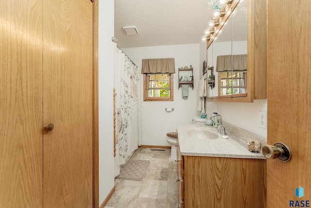 bathroom with vanity, toilet, and baseboards
