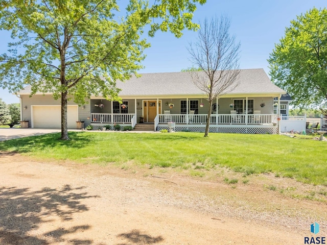 ranch-style house featuring a porch, concrete driveway, a garage, and a front yard
