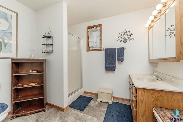 full bath with a stall shower, vanity, and baseboards