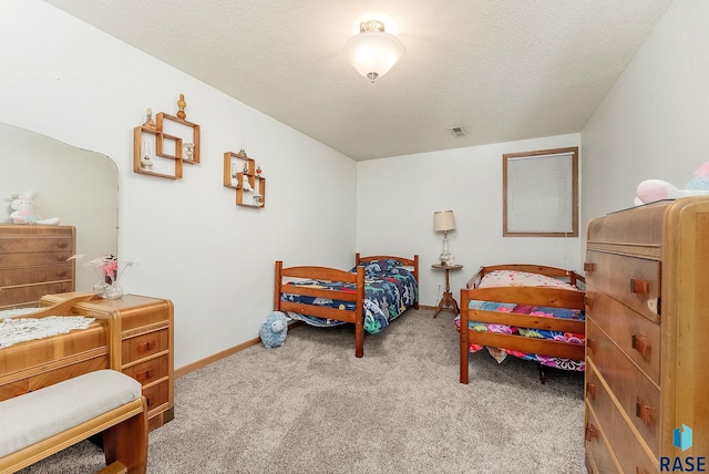 bedroom featuring carpet floors, baseboards, and a textured ceiling