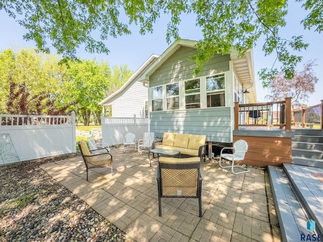 back of property with a patio, a deck, fence, and an outdoor living space